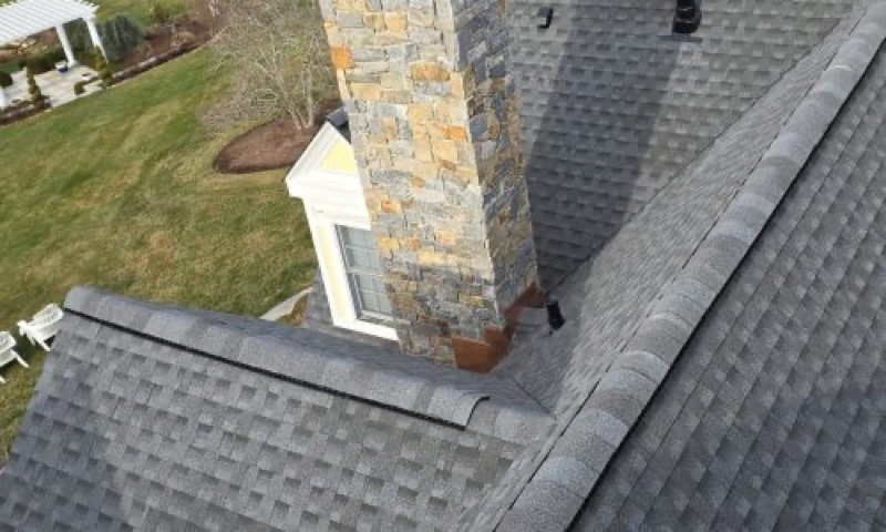 A brick chimney flashed into a freshly shingled roof